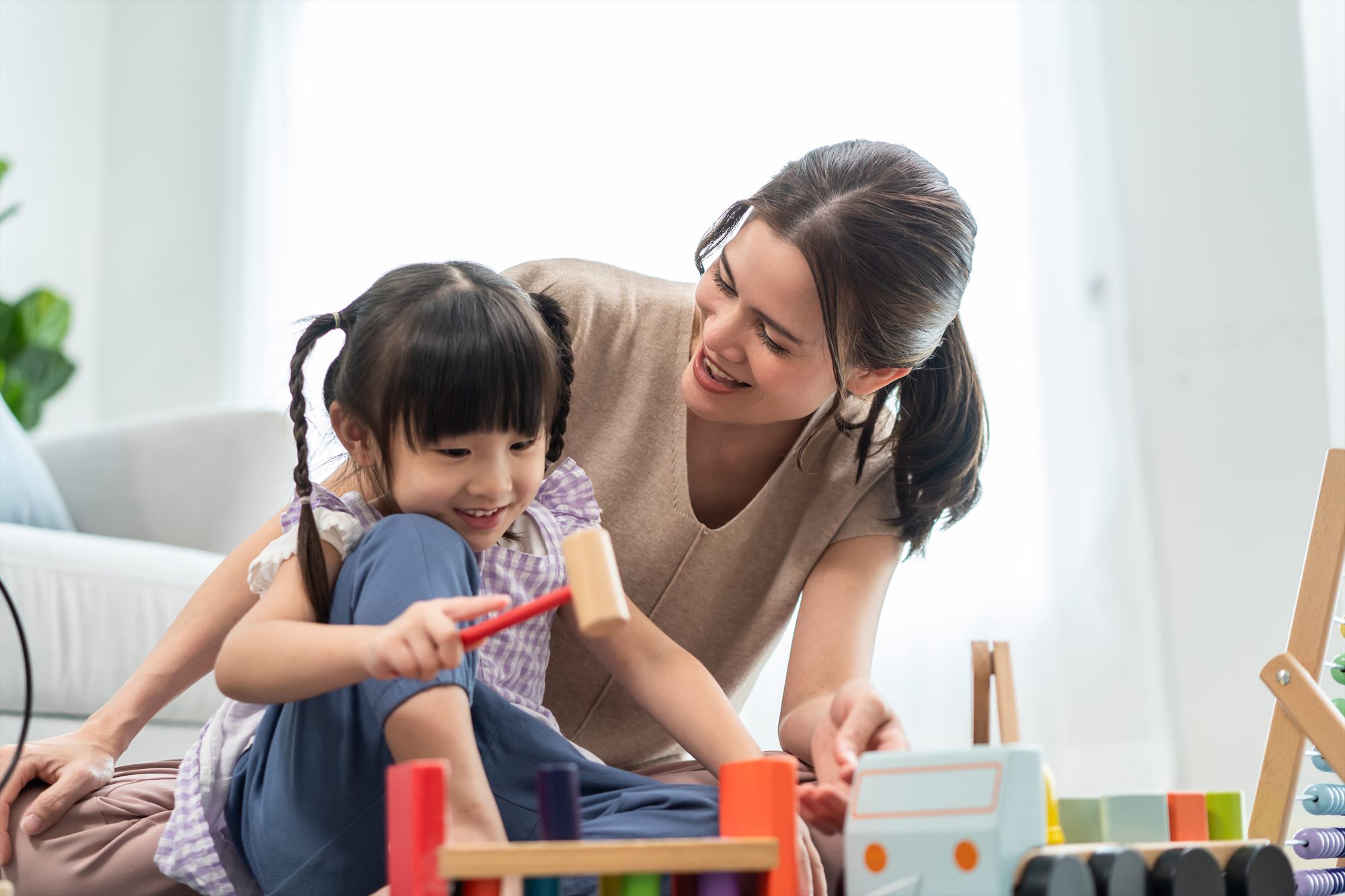 A parent and child playing with wooden blocks together